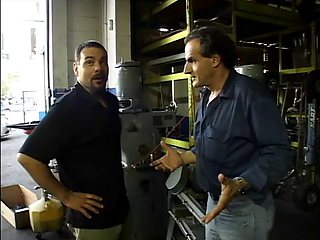 Two service technicians drill pretty brunette in the garage