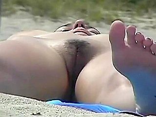 Busty girl shows her mighty jugs on a nudist beach