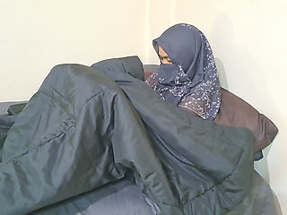 A woman in a hijab is masturbating on the sly.