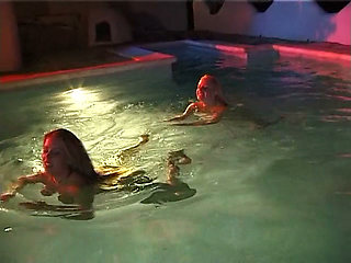 Two sexy lesbian chicks are swimming together in the swimming pool