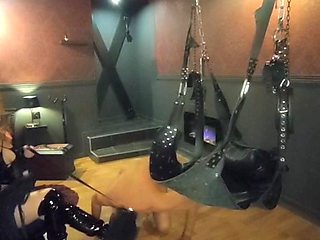 Mistress Acanthus raises her slave on a leash to the whip on the cross