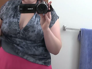 Busty Redhead in Glasses Films Herself Naked in the Bathroom Mirror