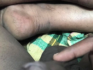 An Indian man is giving himself a massage in his bedroom.