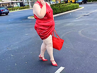 Beautiful woman walking outdoors in public parking lot showing off for strangers