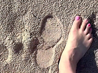 Comparing Size 16 Feet to Sand Prints at the Beach