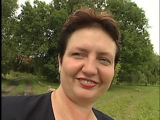 Lovely mature lady blows a guy's cock outdoors near the car