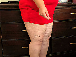 Beautiful social media model in mini red dress and high heels showing off