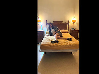 Beautiful Spanish trans girl poses seductively in the bedroom with a latex miniskirt and high heels.