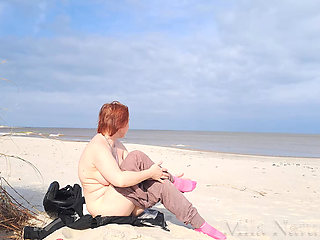 A biker girl strips naked and masturbates on a wild beach.