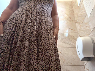 A horny mature MILF is very aroused and is rubbing her pussy in the public restroom at the office.