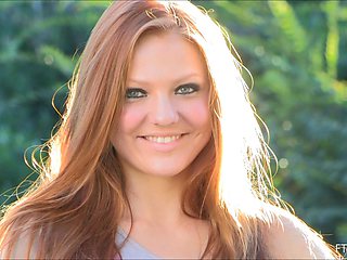 A beautiful redhead with long hair and natural breasts performs solo.