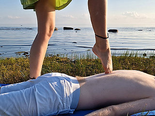 Foot massage by girl with long toes, long slim legs in skirt