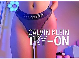 Redhead slips into sheer Calvin Klein, teasing lace against smooth skin