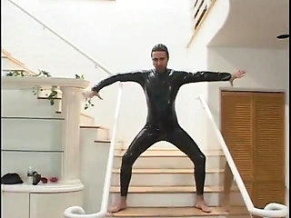 Two guys wearing masks get their large cocks sucked by a hot chick in latex gear